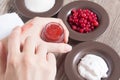 A woman puts her finger on a natural home scrub. Skin care. Natural ingredients for making a scrub, sugar, cream, berries.