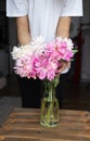 woman puts peonies flowers in vase. Housewife enjoying decor and interior of kitchen. Sweet home. Allergy free. Royalty Free Stock Photo