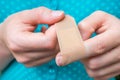 Woman puts a plaster on her injured finger Royalty Free Stock Photo
