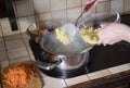 a woman puts potatoes in a pot in the kitchen, ingredients borsch soup