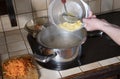 a woman puts potatoes in a pot in the kitchen, ingredients borsch soup