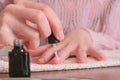 Woman puts primer on her nails before putting shellac. Close-up hands.