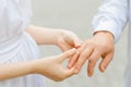 Woman puts a ring on her man finger. The bride gives the wedding ring to the groom. Without face Royalty Free Stock Photo