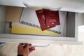A woman puts Russian passports in a drawer, on a shelf. Travel forbidden