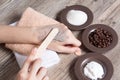 A woman puts a spatula of coffee homemade scrub on her hand. SPA, beauty. Ingredients for making scrub, coffee beans, sugar, cream