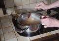 a woman puts tomato paste in a pot,ingredients for cooking borsch soup