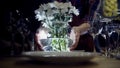 Woman puts vase of flowers on table. Action. Close-up of woman puts vase of white flowers on serving table with Royalty Free Stock Photo