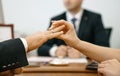 Woman puts a wedding ring in a registry office for a man. Marriage and hands close-up against the background of the ceremony maste Royalty Free Stock Photo