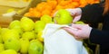 Woman is putting apples in reusable shopping bag. Zero waste. Ecologically and environmentally friendly packets. Canvas and linen Royalty Free Stock Photo