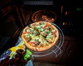 Woman putting baking sheet with pizza in oven Royalty Free Stock Photo