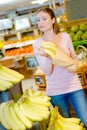 Woman putting banana inside paperbag