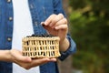 Woman putting bilberry into wicker bowl outdoors, closeup. Space for text Royalty Free Stock Photo