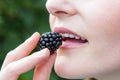 Woman putting blackberry into mouth