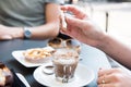 Woman is putting brown sugar in her drink