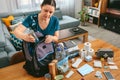 Woman putting cans of food to prepare emergency backpack