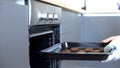 Woman putting chocolate cookies in oven, recipes of homemade baking, confection Royalty Free Stock Photo