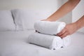 Woman putting clean white towels on bed indoors Royalty Free Stock Photo