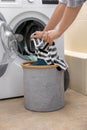 Woman putting clothes into washing machine at home Royalty Free Stock Photo