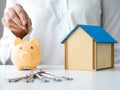 Woman putting coins in piggy bank. Savings for buy own home concept Royalty Free Stock Photo