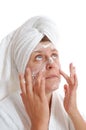 Woman putting cream on her face