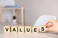 Woman putting cubes with word VALUES on wooden table, closeup Royalty Free Stock Photo