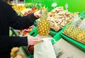 Woman is putting fruit in reusable shopping bag. Ecologically and environmentally friendly packets. Canvas and linen fabrics. Save Royalty Free Stock Photo