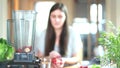 Woman putting fruits in blender for blending