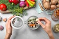 Woman putting garlic into glass jar at grey table. Pickling mushrooms Royalty Free Stock Photo