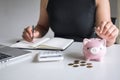 Woman putting golden coin in pink piggy bank for step up growing business to profit and saving with piggy bank, Saving money for Royalty Free Stock Photo