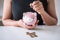 Woman putting golden coin in pink piggy bank for step up growing business to profit and saving with piggy bank, Saving money for Royalty Free Stock Photo