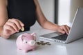 Woman putting golden coin in pink piggy bank for step up growing business to profit and saving with piggy bank, Saving money for Royalty Free Stock Photo