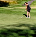 A woman on the putting green at a golf tournament