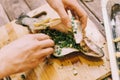 Woman putting greenery in raw fish for cooking. Royalty Free Stock Photo