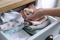 Woman putting heart shaped scented wax sachet into dresser drawer with folded clothes at home, closeup Royalty Free Stock Photo