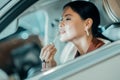 Woman putting on her lipstick in the car. Royalty Free Stock Photo