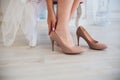 Woman putting on high heel shoes, top view.