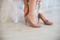 Woman putting on high heel shoes, top view.