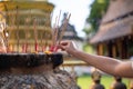 A woman putting the incense sticks in the incense burner after making a wish at a temple Royalty Free Stock Photo