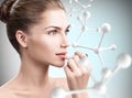 Woman putting lipbalm in big molecules chain. Royalty Free Stock Photo