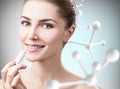 Woman putting lipbalm in big molecules chain. Royalty Free Stock Photo