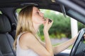 woman putting on lipstick in car Royalty Free Stock Photo