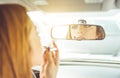 Woman putting lipstick in the car. Royalty Free Stock Photo