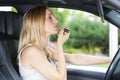 Woman putting on lipstick in car Royalty Free Stock Photo