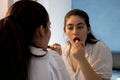 Woman putting lipstick on her lips in a room. Doing make up. Looking at the mirror Royalty Free Stock Photo