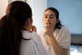 Woman putting lipstick on her lips in a room. Doing make up. Looking at the mirror Royalty Free Stock Photo