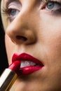 Woman putting lipstick on her lips Royalty Free Stock Photo