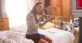 Woman Putting On Make Up And Man Getting Dressed In Bedroom Royalty Free Stock Photo