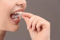 Woman putting occlusal splint in mouth on grey background, closeup Royalty Free Stock Photo