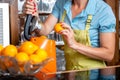 Woman putting oranges in blender Royalty Free Stock Photo