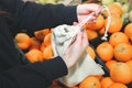 Woman is putting oranges in reusable shopping bag. Zero waste. Ecologically and environmentally friendly packets. Canvas and linen Royalty Free Stock Photo